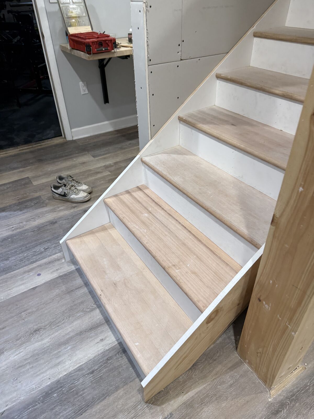 Basement stairs with new oak treads, white risers and plank flooring